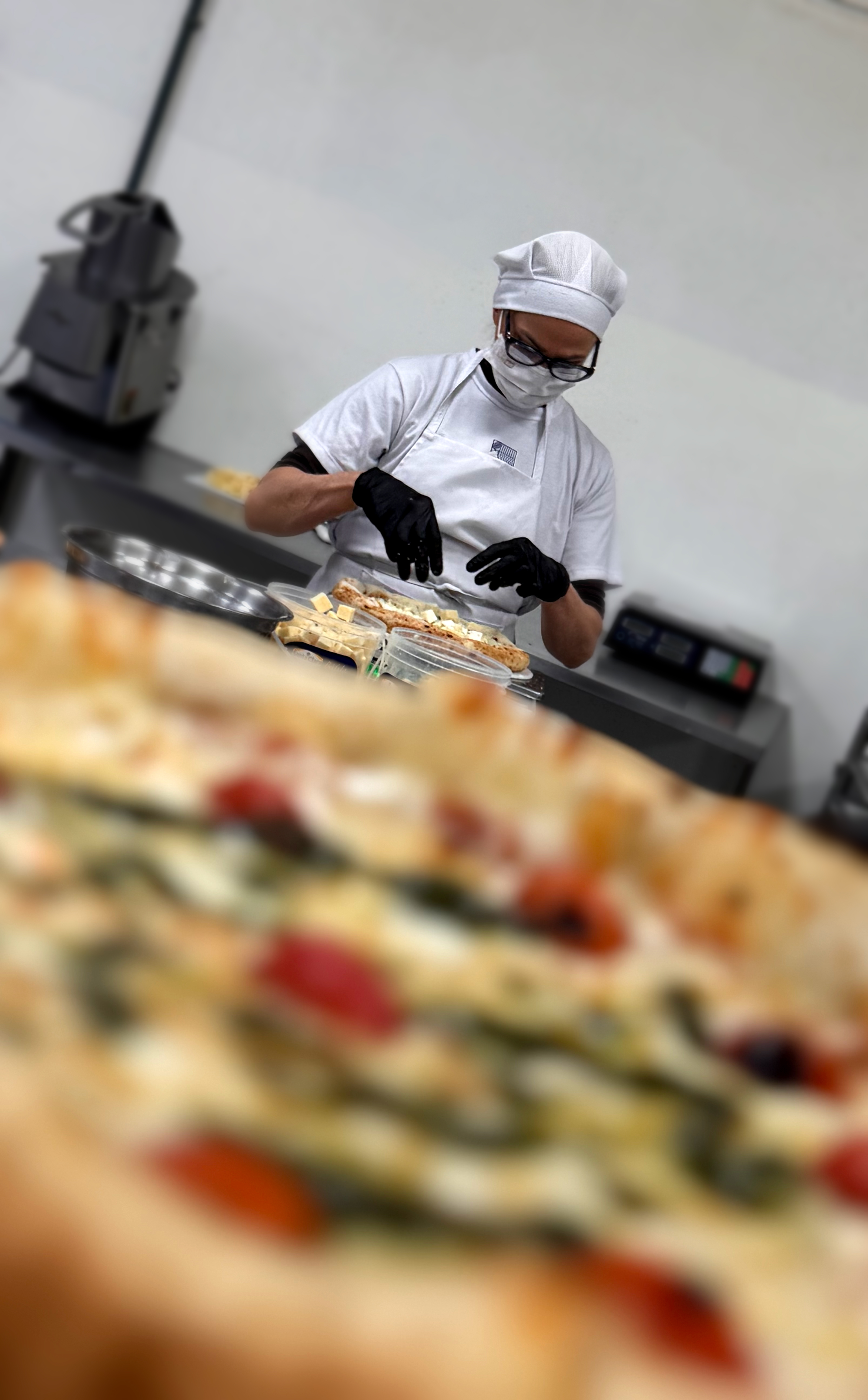 Funcionárias montando pizzas artesanais na bancada da fábrica Dafra